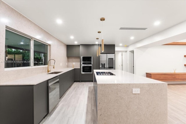 11505 NE 11th Pl, Biscayne Park, FL 33161 - kitchen featuring a sink, appliances with stainless steel finishes, modern cabinets, a kitchen island, and light wood-style flooring