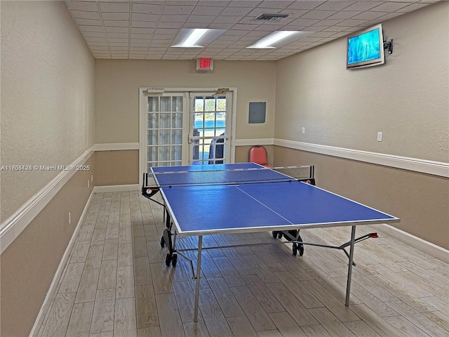 2597 SE 7th Ct, Homestead, FL 33033 - recreation room with wood finished floors, baseboards, a textured wall, and a drop ceiling