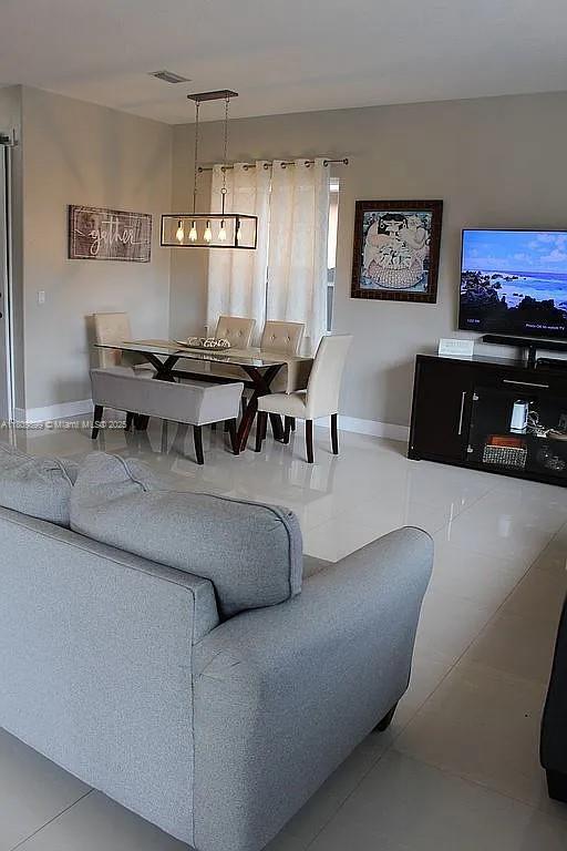 16272 SW 42nd Ter, Miami, FL 33185 - tiled living room featuring baseboards and a chandelier