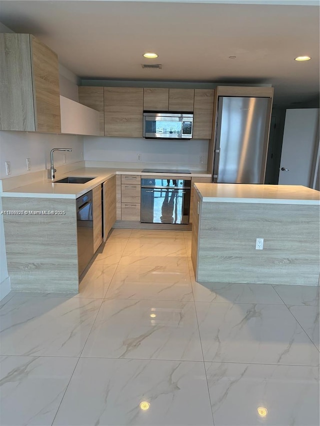 16385 Biscayne Blvd Unit 504, North Miami Beach, FL 33160 - kitchen featuring black appliances, modern cabinets, a sink, light countertops, and light marble finish floors