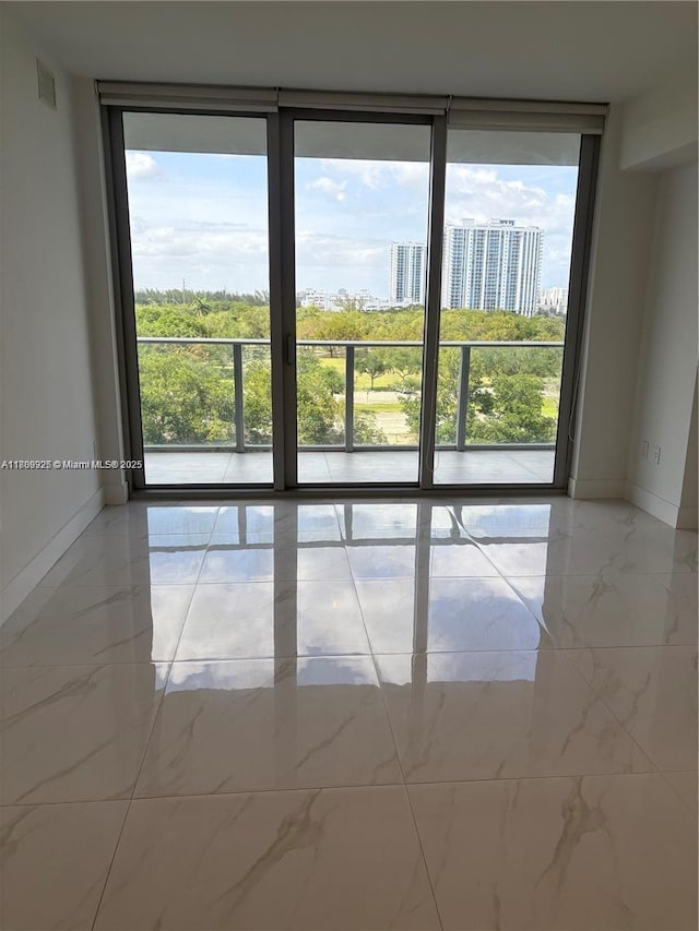 16385 Biscayne Blvd Unit 504, North Miami Beach, FL 33160 - spare room featuring floor to ceiling windows, baseboards, and marble finish flooring