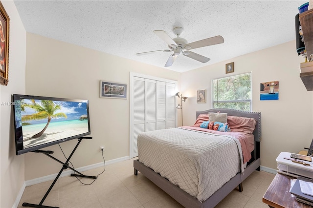 2330 SW Lejune St, Port St Lucie, FL 34953 - bedroom with a closet, a textured ceiling, ceiling fan, baseboards, and light tile patterned flooring