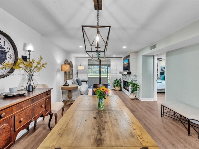 1489 Fairway Rd, Pembroke Pines, FL 33026 - dining room with wood finished floors, a fireplace with raised hearth, and recessed lighting