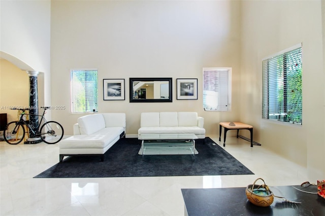 7753 SW 193rd St, Cutler Bay, FL 33157 - living area featuring a high ceiling, arched walkways, plenty of natural light, tile patterned flooring, and ornate columns