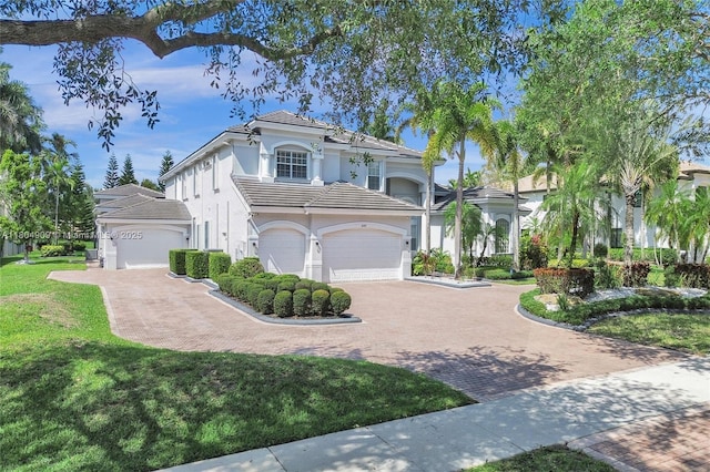 10457 Laurel Rd, Davie, FL 33328 - mediterranean / spanish house with stucco siding, decorative driveway, a tiled roof, and a front lawn