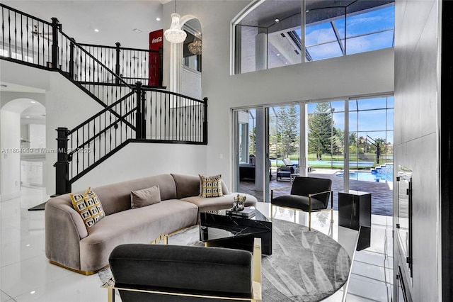 10457 Laurel Rd, Davie, FL 33328 - living area with a high ceiling, arched walkways, stairway, and tile patterned floors