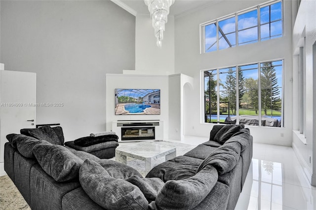 10457 Laurel Rd, Davie, FL 33328 - tiled living room with a high ceiling, crown molding, baseboards, and a glass covered fireplace