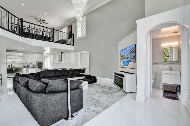 10457 Laurel Rd, Davie, FL 33328 - living room with arched walkways, ceiling fan, light tile patterned flooring, ornamental molding, and baseboards