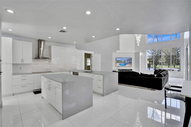 10457 Laurel Rd, Davie, FL 33328 - kitchen with wall chimney range hood, a sink, modern cabinets, black electric cooktop, and recessed lighting