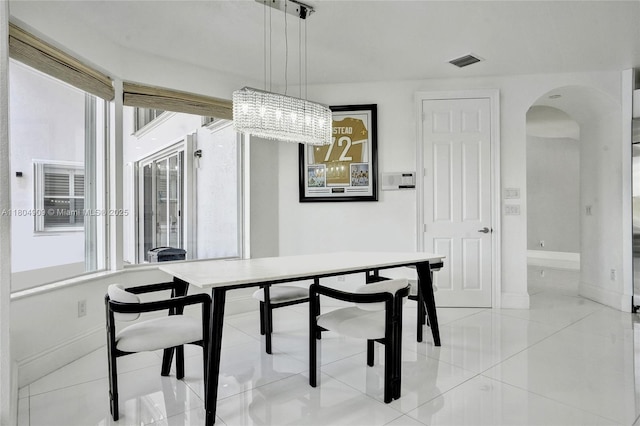 10457 Laurel Rd, Davie, FL 33328 - dining room with arched walkways, baseboards, a chandelier, and light tile patterned flooring