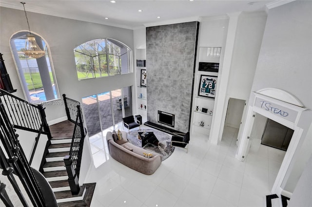 10457 Laurel Rd, Davie, FL 33328 - tiled living room featuring ornamental molding, a chandelier, recessed lighting, baseboards, and a tile fireplace