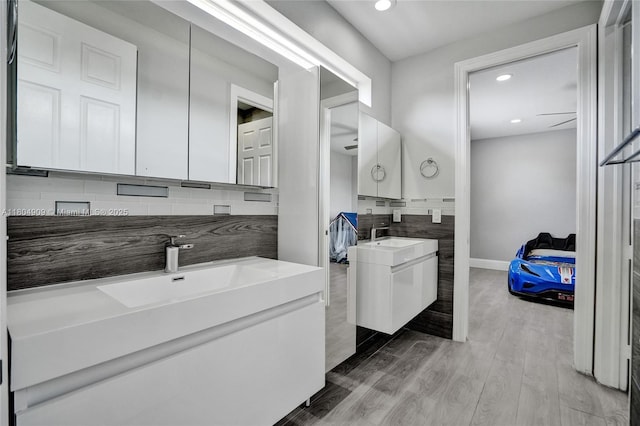 10457 Laurel Rd, Davie, FL 33328 - full bathroom with two vanities, recessed lighting, backsplash, wood finished floors, and baseboards