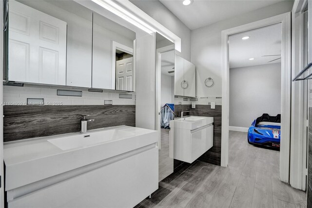 10457 Laurel Rd, Davie, FL 33328 - full bathroom with two vanities, recessed lighting, backsplash, wood finished floors, and baseboards