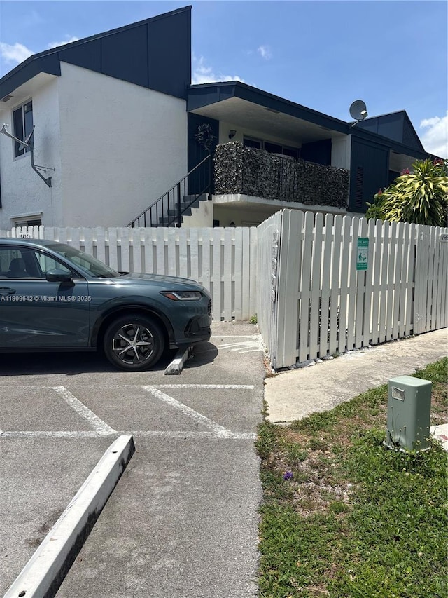 15428 SW 85th Ln Unit 159, Miami, FL 33193 - view of side of property with a fenced front yard, stucco siding, and stairway
