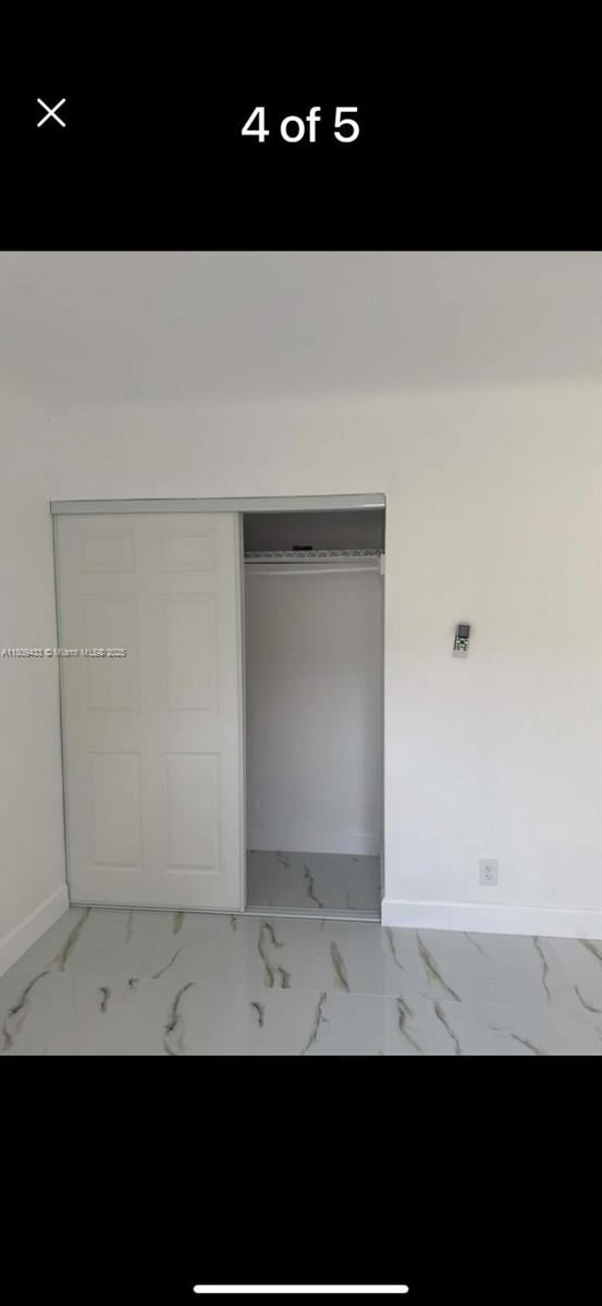 7821 NW 30th St, Davie, FL 33024 - interior space featuring baseboards, marble finish floors, and a closet