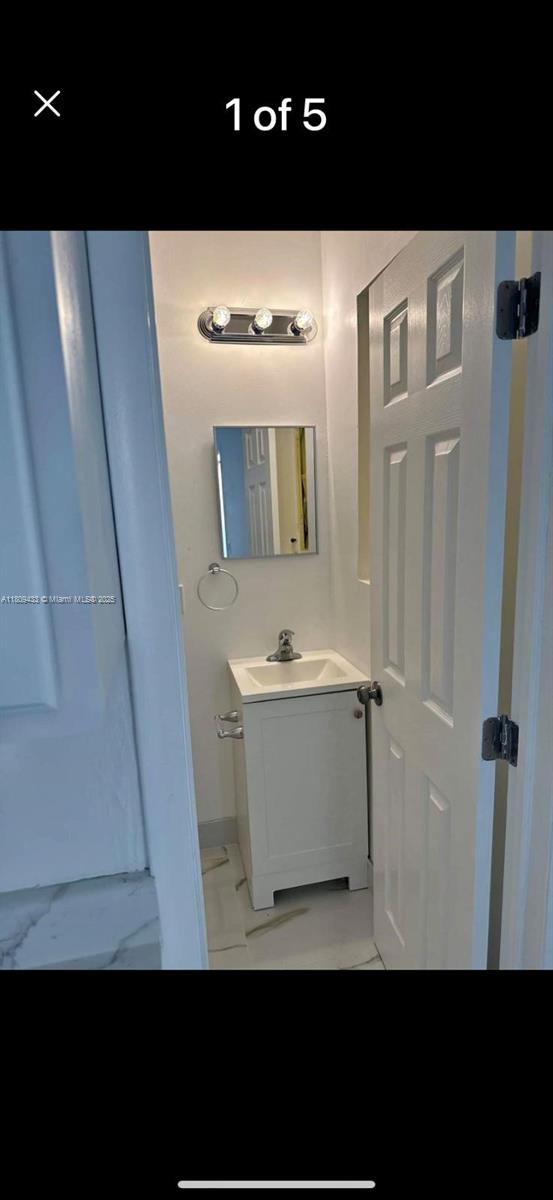 7821 NW 30th St, Davie, FL 33024 - bathroom with vanity, marble finish floors, and baseboards