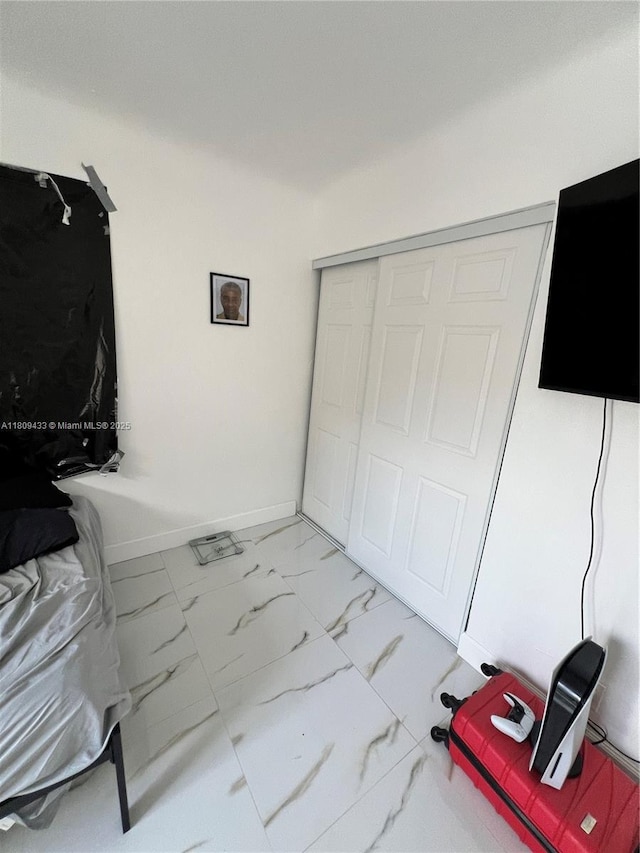 7821 NW 30th St, Davie, FL 33024 - unfurnished bedroom with light marble finish floors, a closet, and baseboards