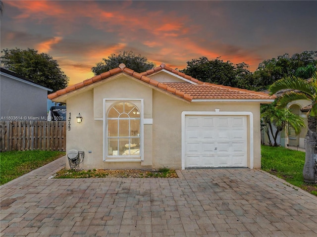 14723 SW 155th Pl, Miami, FL 33196 - mediterranean / spanish house featuring an attached garage, stucco siding, decorative driveway, and a tile roof