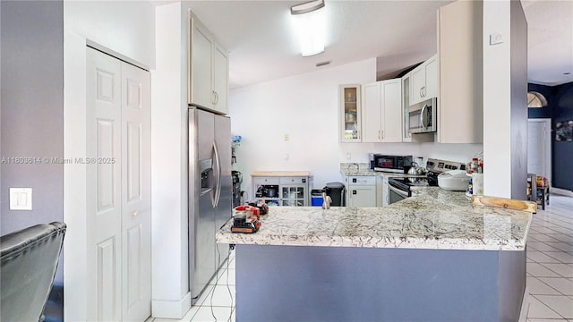 14723 SW 155th Pl, Miami, FL 33196 - kitchen featuring stainless steel appliances, light tile patterned flooring, light stone counters, and a peninsula