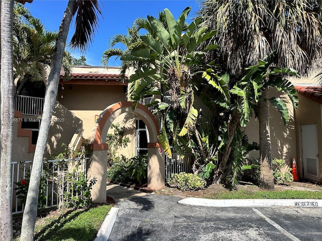301 SW 86th Ave Unit 208, Pembroke Pines, FL 33025 - view of front of home with stucco siding, a tiled roof, and uncovered parking