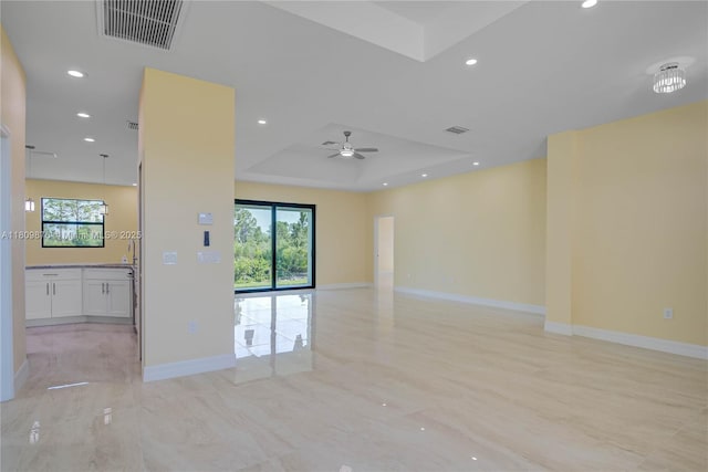 637 Cardinal St E, Lehigh Acres, FL 33974 - spare room featuring a raised ceiling, plenty of natural light, ceiling fan, recessed lighting, and baseboards