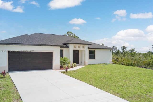 637 Cardinal St E, Lehigh Acres, FL 33974 - prairie-style home with an attached garage, stucco siding, driveway, a front lawn, and a shingled roof