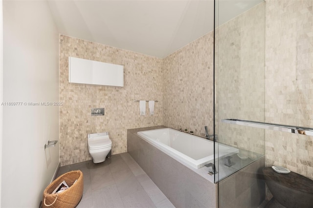 68 SE 6th St Unit 1703, Miami, FL 33131 - full bathroom with tile walls, toilet, a garden tub, and tile patterned flooring