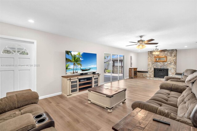 4271 SW 67th Ter, Davie, FL 33314 - living room with light wood-style flooring, ceiling fan, baseboards, a stone fireplace, and recessed lighting