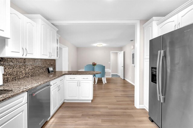 4271 SW 67th Ter, Davie, FL 33314 - kitchen featuring stainless steel appliances, white cabinetry, a peninsula, light wood-style floors, and tasteful backsplash