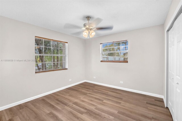 4271 SW 67th Ter, Davie, FL 33314 - unfurnished bedroom featuring multiple windows, a closet, wood finished floors, and baseboards