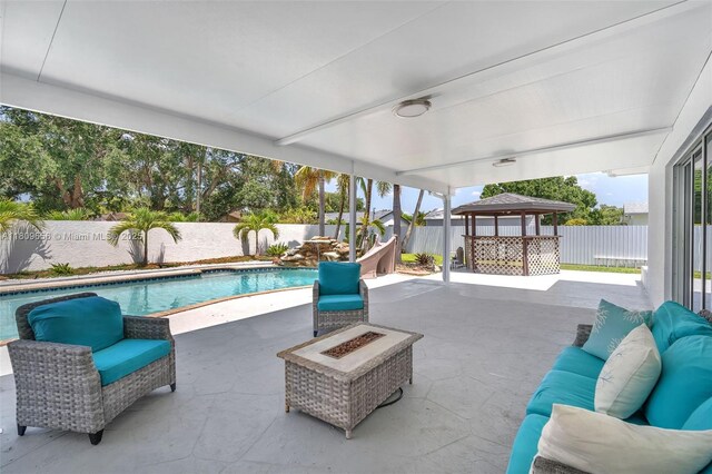 4271 SW 67th Ter, Davie, FL 33314 - view of swimming pool with an outdoor living space with a fire pit, a gazebo, a fenced backyard, and a patio