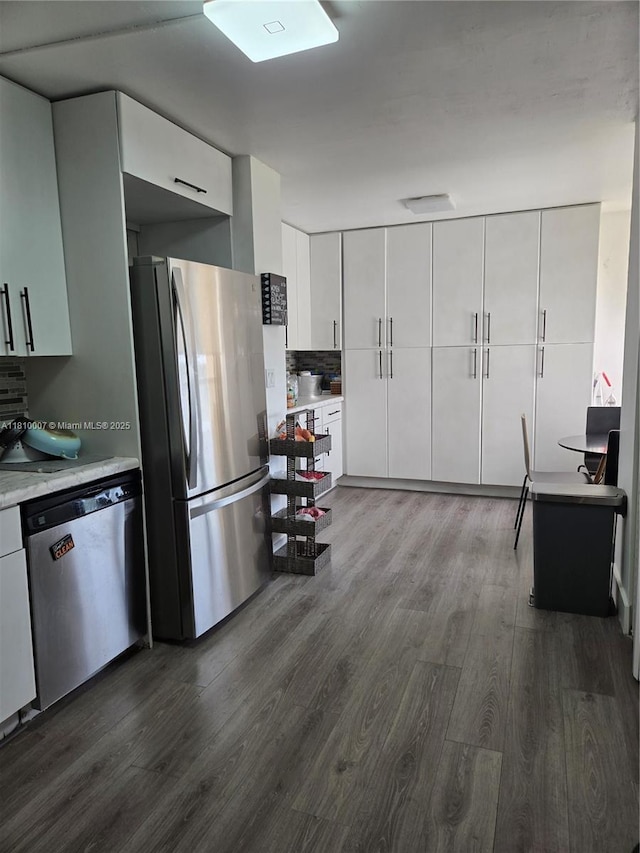 900 NE 195th St Unit 709, Miami, FL 33179 - kitchen featuring appliances with stainless steel finishes, dark wood-type flooring, light countertops, and white cabinets