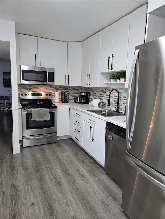 900 NE 195th St Unit 709, Miami, FL 33179 - kitchen with stainless steel appliances, a sink, wood finished floors, and decorative backsplash