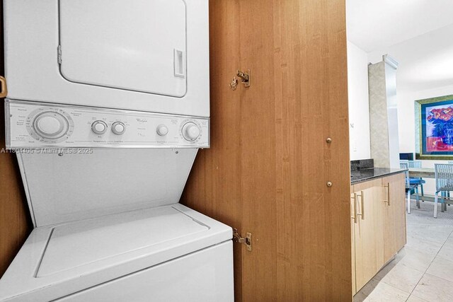 10275 Collins Ave Unit 1506, Bal Harbour, FL 33154 - laundry area with stacked washer and clothes dryer and light tile patterned flooring