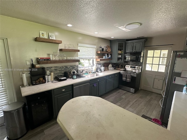 1230 F Rd, Loxahatchee, FL 33470 - kitchen featuring appliances with stainless steel finishes, a sink, wood finished floors, open shelves, and a textured ceiling