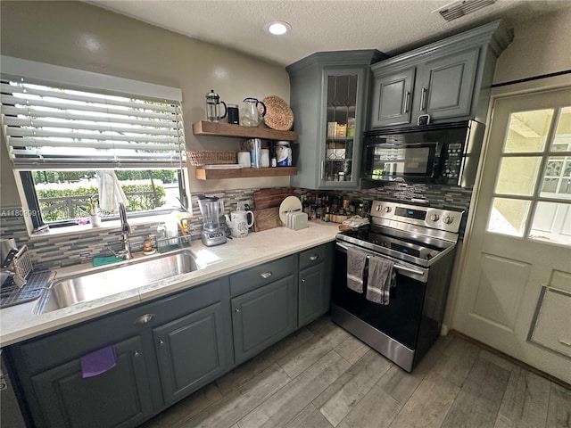 1230 F Rd, Loxahatchee, FL 33470 - kitchen with electric range, gray cabinets, black microwave, a sink, and a textured ceiling