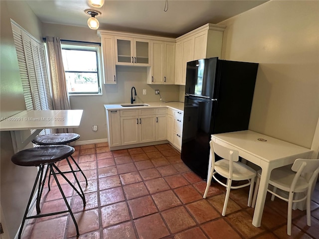 1230 F Rd, Loxahatchee, FL 33470 - kitchen featuring freestanding refrigerator, a sink, light countertops, glass insert cabinets, and white cabinetry