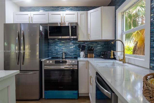 460 Barry Ave, Lower Keys, FL 33042 - kitchen featuring stainless steel appliances, a sink, white cabinetry, backsplash, and light stone counters