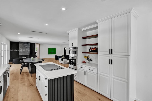 7941 SW 143rd St, Palmetto Bay, FL 33158 - kitchen with black electric cooktop, stainless steel double oven, open shelves, light countertops, and white cabinetry