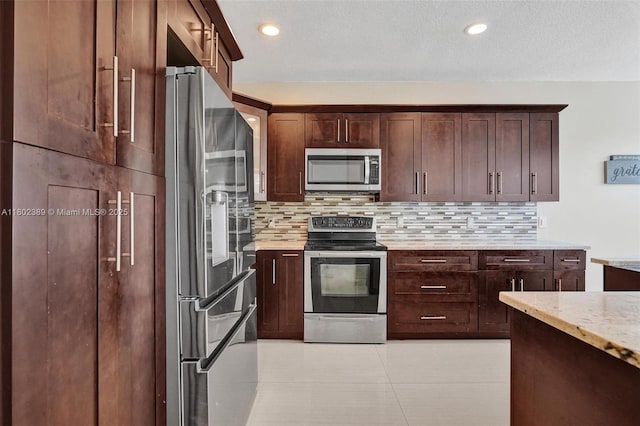 1070 Briar Ridge Rd, Weston, FL 33327 - kitchen featuring appliances with stainless steel finishes, backsplash, light stone countertops, dark brown cabinets, and recessed lighting