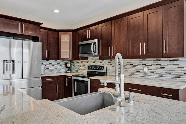 1070 Briar Ridge Rd, Weston, FL 33327 - kitchen featuring appliances with stainless steel finishes, glass insert cabinets, light stone countertops, tasteful backsplash, and recessed lighting
