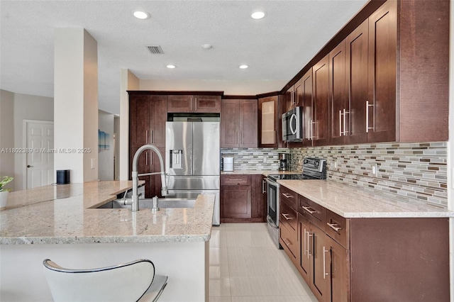 1070 Briar Ridge Rd, Weston, FL 33327 - kitchen featuring appliances with stainless steel finishes, light stone counters, a sink, tasteful backsplash, and glass insert cabinets