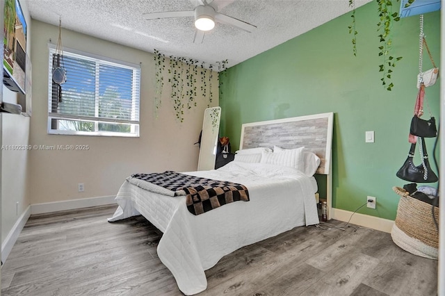 1070 Briar Ridge Rd, Weston, FL 33327 - bedroom with wood finished floors, a textured ceiling, baseboards, and a ceiling fan