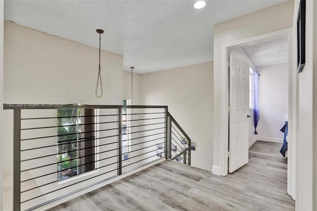 1070 Briar Ridge Rd, Weston, FL 33327 - hallway with an upstairs landing, a textured ceiling, wood finished floors, baseboards, and recessed lighting