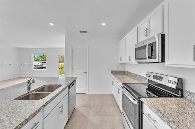 1130 SW Jericho Ave, Port St Lucie, FL 34953 - kitchen with appliances with stainless steel finishes, light stone counters, white cabinetry, and recessed lighting