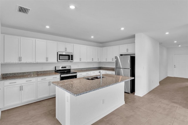 1130 SW Jericho Ave, Port St Lucie, FL 34953 - kitchen with stainless steel appliances, white cabinets, stone counters, recessed lighting, and a kitchen island with sink