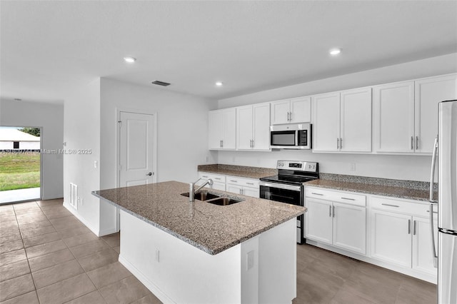 1130 SW Jericho Ave, Port St Lucie, FL 34953 - kitchen with appliances with stainless steel finishes, stone counters, an island with sink, white cabinetry, and recessed lighting