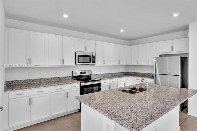 1130 SW Jericho Ave, Port St Lucie, FL 34953 - kitchen with stainless steel appliances, white cabinetry, light stone countertops, recessed lighting, and light tile patterned floors