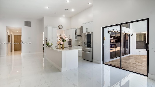 10412 NW 6th St, Coral Springs, FL 33071 - kitchen with appliances with stainless steel finishes, wall chimney range hood, white cabinetry, a center island, and a high ceiling