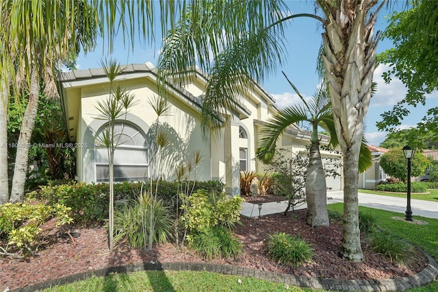 5708 NW 47th Ct, Coral Springs, FL 33067 - view of side of home with stucco siding, concrete driveway, and a garage